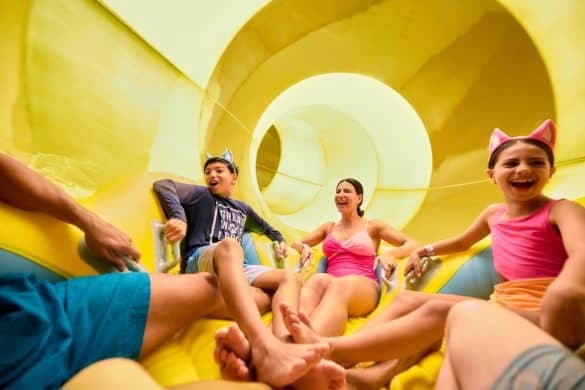 Family of parents and children on a large group raft on a waterslide at Great Wolf Lodge waterpark